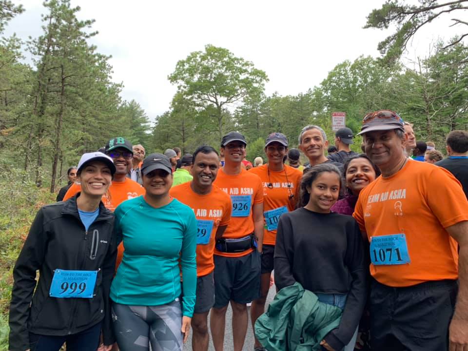 Runner in orange TeamAID shirt mid-race