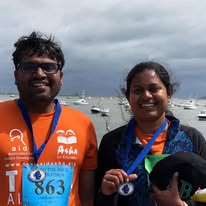 Runner with thumbs up in TeamAidAsha shirt