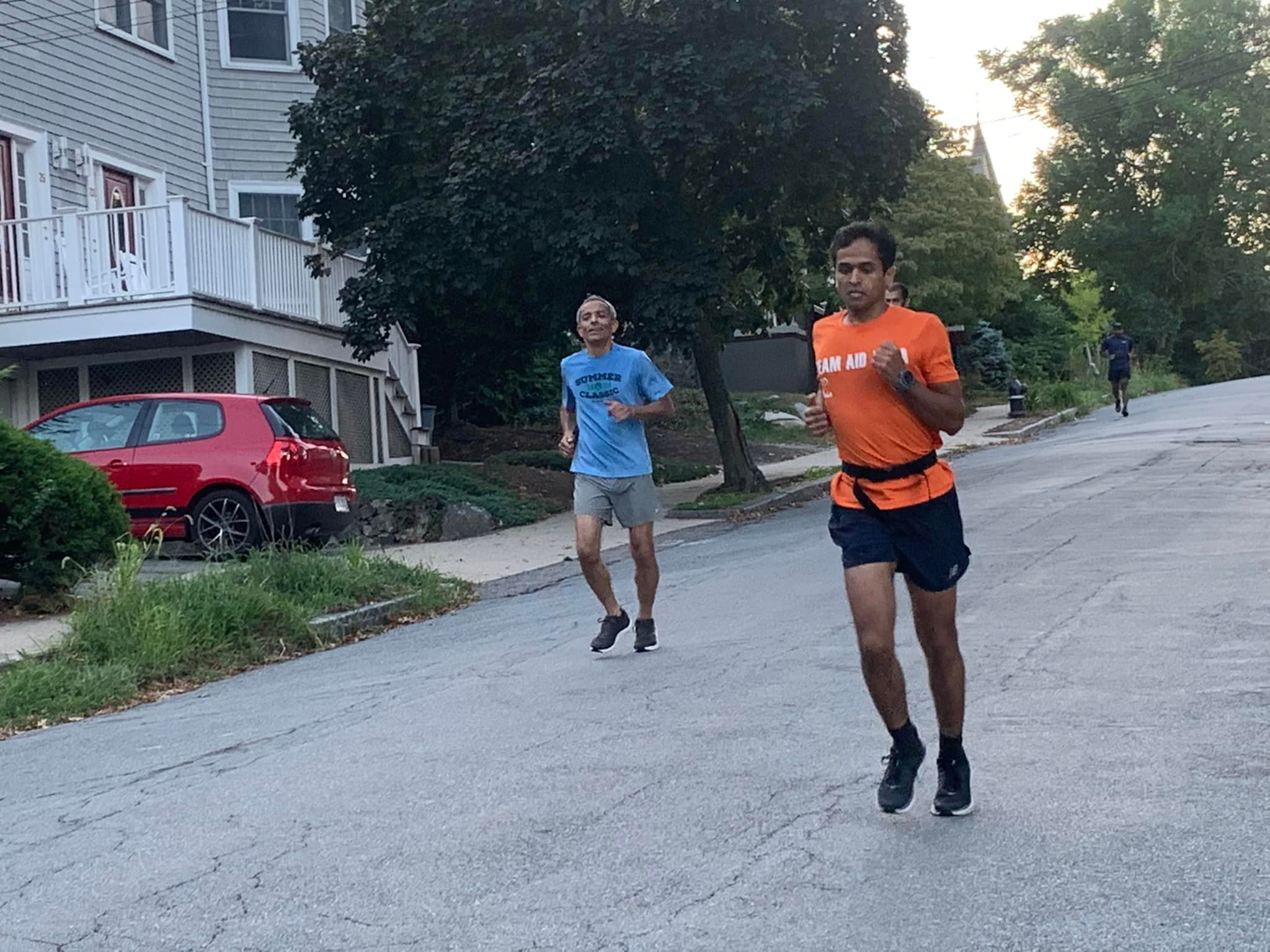 Two runners on residential street at dusk