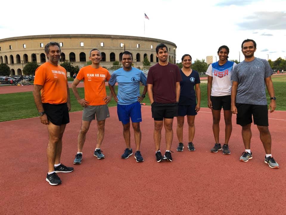 Runners on street in Team Aid Asha shirts